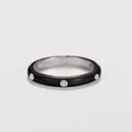 Close-up detail of a minimalist black enamel ring with embedded sparkling zircons. - Black