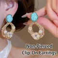 Orecchini a clip vintage dorati con pietra blu, perle e raffinati dettagli floreali - Orecchino a clip - Fiore oro