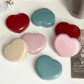 A close-up view of multiple heart-shaped contact lens cases in vibrant candy colors - Multicolor
