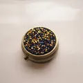 Portable round metal pill box with sparkling blue and gold rhinestone lid design - Bronze - Gold Blue Rhinestone
