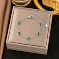 Elegante pulsera de cadena plateada con cinco piedras verdes rectangulares en un joyero - Cinco Piedras de Strass Verdes (E220) / Color acero