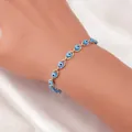 Gros plan d'un bracelet délicat œil porte-bonheur doré avec des perles bleues au poignet - Or Bleu Clair