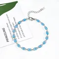 Gros plan d'un bracelet œil de protection argenté avec perles bleues sur décor blanc. - Argent Bleu Clair