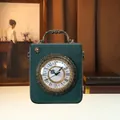 Nahaufnahme einer dunkelgrünen Vintage-Handtasche mit echtem funktionalem Zifferblatt - Blau