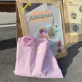 Rosa-weiß gestreifte Canvas-Tragetasche an einem Holzschild in lässiger Außenumgebung - Rosa