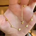 Gros plan d'un collier en or avec cinq pendentifs en forme de cœur sertis de diamants. - Or (Plusieurs Cœurs 3D)