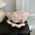 Quilted pink puffer waist bag with ruffled strap and floral zipper pull. - One Size / Pink