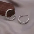 Détail de haute qualité de créoles torsadées Mobius argentées sur tissu de soie gris - Boucle d'Oreille Creuse Spirale 3D (E-071-Platine) / Platine