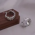 Detailansicht von silbernen Creolen mit strukturiertem Wickeldesign auf Holzsockel - Geometrische Industrielle Block-Ohr-Schnalle (E-073-Platin)