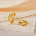 Detailed view of textured gold geometric curved earrings displayed on stone block - Geometric Hammered Style (PJER307) / 20mm / Gold