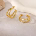 Close-up detail of gold geometric twisted hoop earrings in polished titanium steel. - Twisted Geometric Style (PJER343) / 27mm / Gold
