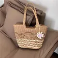 Detailed view of handwoven straw tote bag with floral charm for beach vacations. - 38x24cm / Khaki