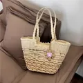 Detailed view of the intricate woven texture and butterfly charm on this straw beach tote - 38x24cm / Off White