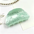 Detail of a green acrylic hair claw clip with a white water ripple marble pattern. - Aqua Green