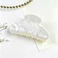 Detailed view of the elegant pearlescent white marble texture on this hair claw clip - White