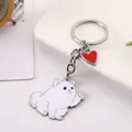 Close-up detail of a cute waving white dog keychain featuring a red heart charm - Pomeranian / 10cm