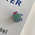 Close-up detail of glittery green monster hand shaped Halloween acrylic hair claw clip - Magic Claw Clip