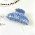Close-up detail of a blue marbled acrylic hair claw clip featuring elegant water ripple pattern. - Glaze Blue