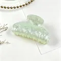 Detalle de la pinza para el cabello de acrílico jaspeado verde con ondas de agua. - Verde claro