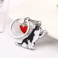Detailed view of a cute waving husky dog keychain with a red heart charm in zinc alloy - Husky (Black & White Spotted) / 10cm