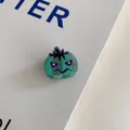 Detail shot of a green glittery pumpkin hair clip for Halloween decor. - Evil Green Pumpkin Clip