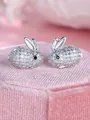 Detailed macro shot of sparkling full-diamond rabbit stud earrings on pink velvet box - White Gold With White Zirconia
