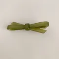 Gros plan d'une élégante pince à cheveux nœud en acétate vert olive et clip doré - Vert