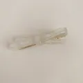 Close-up of pearl white acetate bow hair clip with France Handmade engraving detail - White