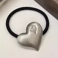 Close-up detail view of a minimalist metal heart charm on a black elastic hair tie - Single Hollow Heart - Silver (12#Hollow-Heart-Silver)
