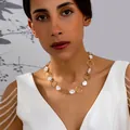 Elegante collar dorado de perlas barrocas con eslabones circulares lucido por una modelo - Círculo Irregular