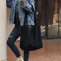 Grande borsa tote in tela nera minimalista mostrata in un ambiente urbano casual ora - Nero