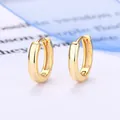 Primo piano di orecchini a cerchio in argento 925 placcato oro su sfondo minimalista - 9mm Oro