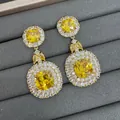 Elegantes pendientes largos con cristales amarillos y detalle de halo. - Amarillo