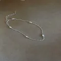 Dettaglio ravvicinato del bracciale in argento 925 con eleganti ciondoli a grana di riso - Argento