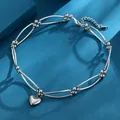 Elegant silver-toned heart pendant necklace featuring a unique bead and bar chain design. - Silver