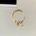 Vue détaillée d'un bracelet câble torsadé doré avec des pendentifs en émail - Glace Arc-en-Ciel
