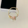 Close-up of gold stainless steel charm bracelet with pink crystals and engraved tag - Full Diamond Dolphin