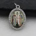 Macro view of an oval pendant featuring a rhinestone border and religious art insert detail. - Silver Saint Painting Illustration Style (DZJFT001) / Silver Floral
