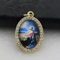 Close-up view of a religious oval pendant with Jesus illustration and rhinestones - Gold Jesus Praying Style (DZJFT001) / Gold Blue Variant 1