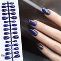 Detailed view of handmade dark blue cat-eye press-on nails with gold patterns. - Gilded Ghost Blue Cat Eye