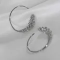 Elegant silver-toned brass wheat ear design hoop earrings presented on white silk - Silver