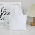 Close-up of a minimalist white canvas tote bag in a lifestyle desk setting - 8oz Open Style / White