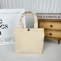 Detailed macro view of cream minimalist canvas tote bag featuring a sturdy metal button closure. - 8oz Snap Button Style / Beige Apricot