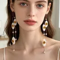 Vintage-style long drop earrings with gold rose detail and pink beads on a model - 2607011 Oval Shell Crystal Rose Long Tassel Earrings
