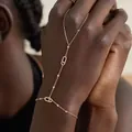 Elegant gold tone hand chain with paved rhinestones and finger ring attachment. - Sliding Oval Style (Bracelet #901) / Gold
