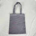 Detailed view of the solid purple thick canvas tote bag on a white textured background - Grey (8oz)
