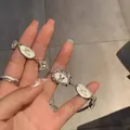 Elegantes silberfarbenes Armband mit weißen Schmetterlingsanhängern und Kristallakzenten - Emailliertes Schmetterling-Buchstabenarmband