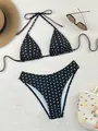 Primer plano de un bikini de lunares en blanco y negro con top halter y braga alta. - S / Negro