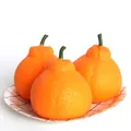 Close-up of three realistic orange-shaped slow rebound stress relief squeeze toys. - Large Mandarin