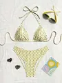 Detalle de un bikini amarillo con lunares extendido sobre una tela blanca tejida - S / Amarillo